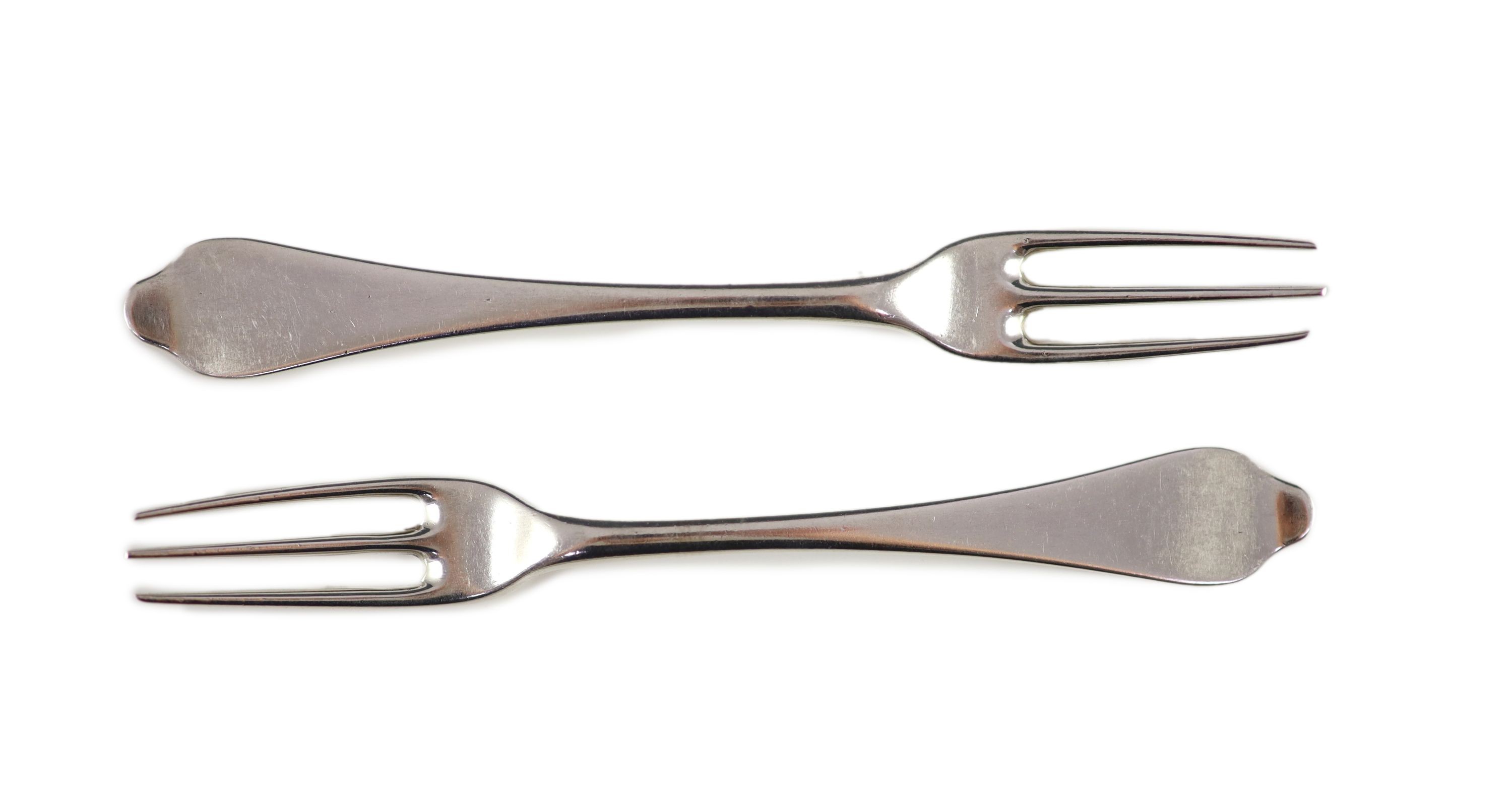 A pair of George I silver three-prong forks, with dog nose terminals, engraved with armorials, London 1722 by Paul Hanet, each 18 cm long, 4oz.